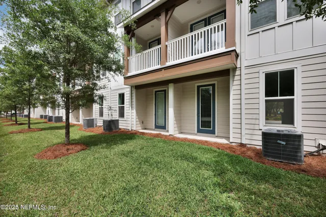 a view of a house with a yard and tree