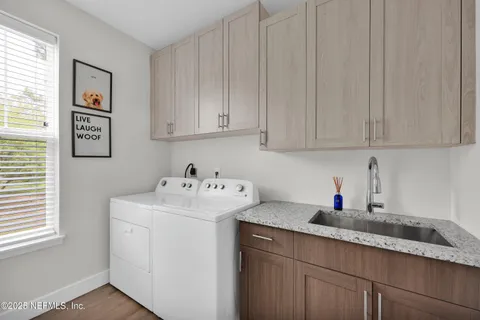 a kitchen with stainless steel appliances granite countertop white cabinets sink and window