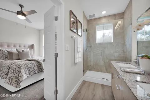 a en suite bathroom with a double vanity sink a large mirror and shower