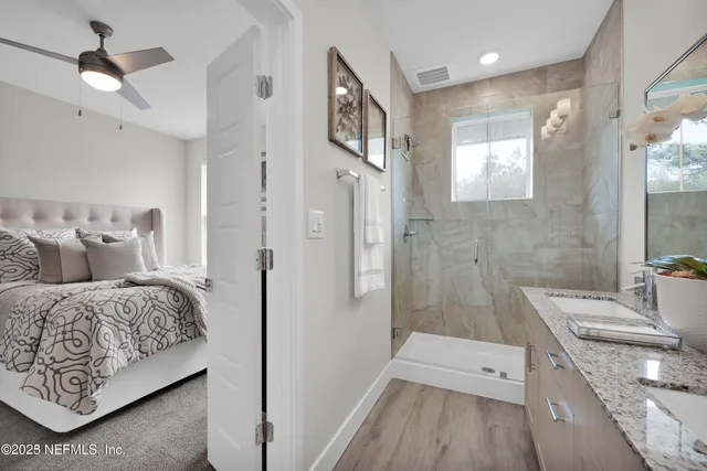 a en suite bathroom with a double vanity sink a large mirror and shower