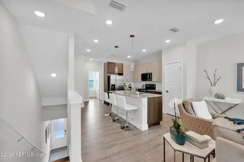 a living room with stainless steel appliances furniture and a table