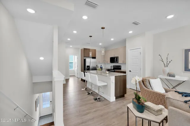 a living room with stainless steel appliances furniture and a table