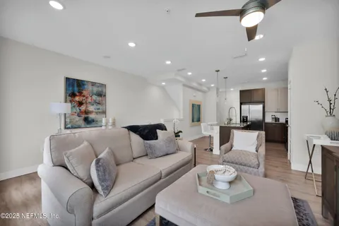 a living room with furniture and a view of kitchen