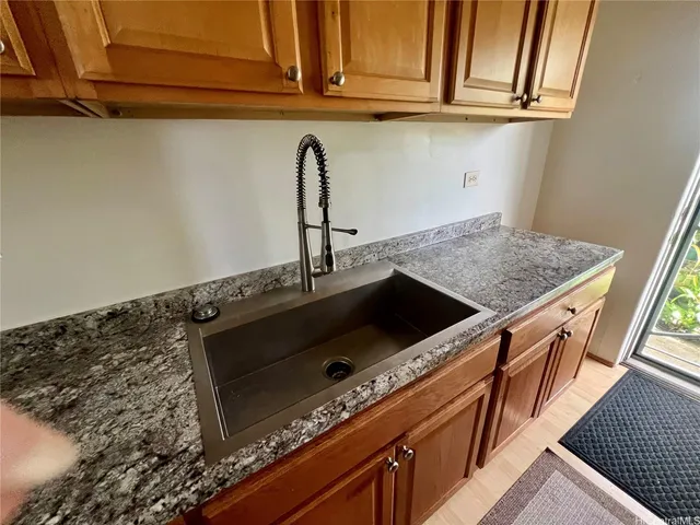 a kitchen with granite countertop a stove and a sink