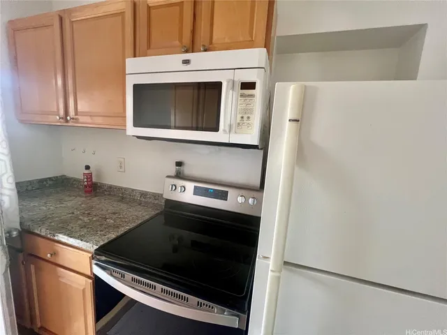 a kitchen with granite countertop white cabinets and stainless steel appliances