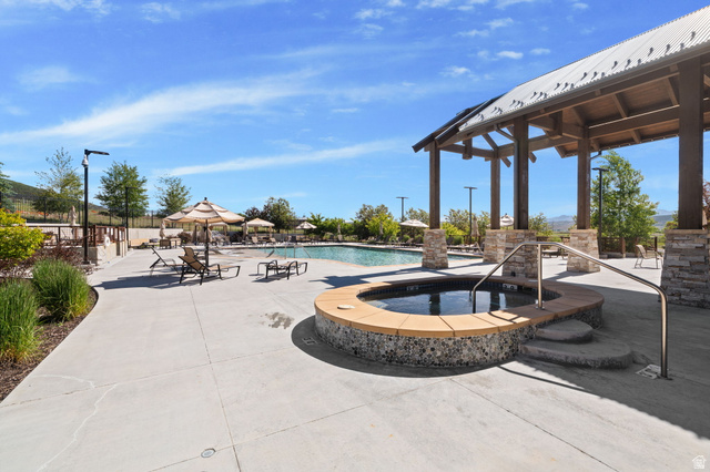910 Wasatch Drive Kamas, UT 84036 - Photo 30 of 36 Outdoor recreation area featuring a built-in spa with mosaic tile and stone surround, a swimming pool, and an expansive concrete deck