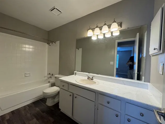 a bathroom with a double vanity sink toilet and shower