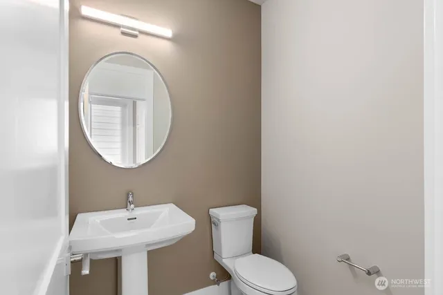 a bathroom with a toilet a sink and a mirror