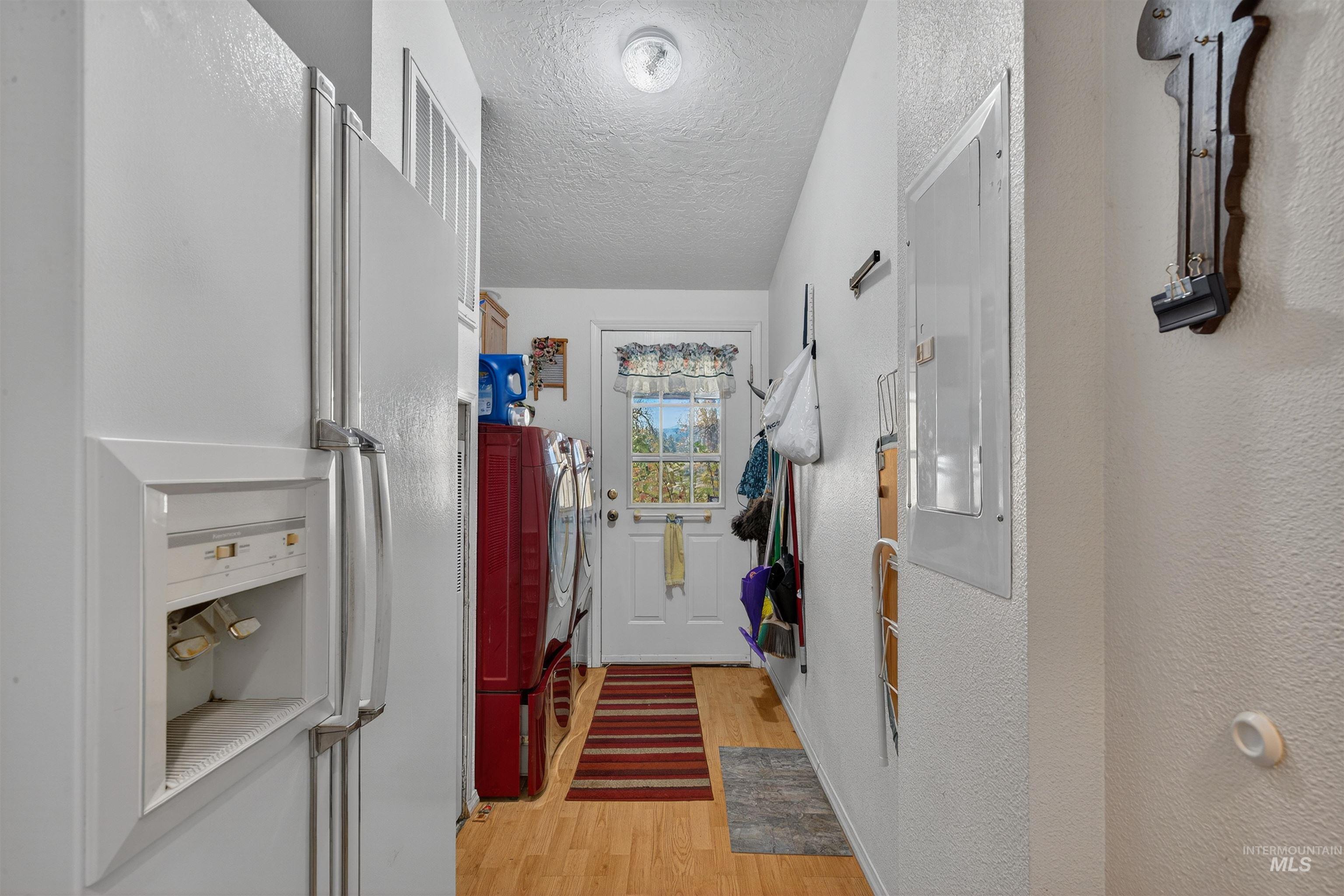 4151 Highway 13 Stites, ID 83552 - Photo 23 of 50 Doorway with wood finished floors, electric panel, a textured ceiling, and a textured wall