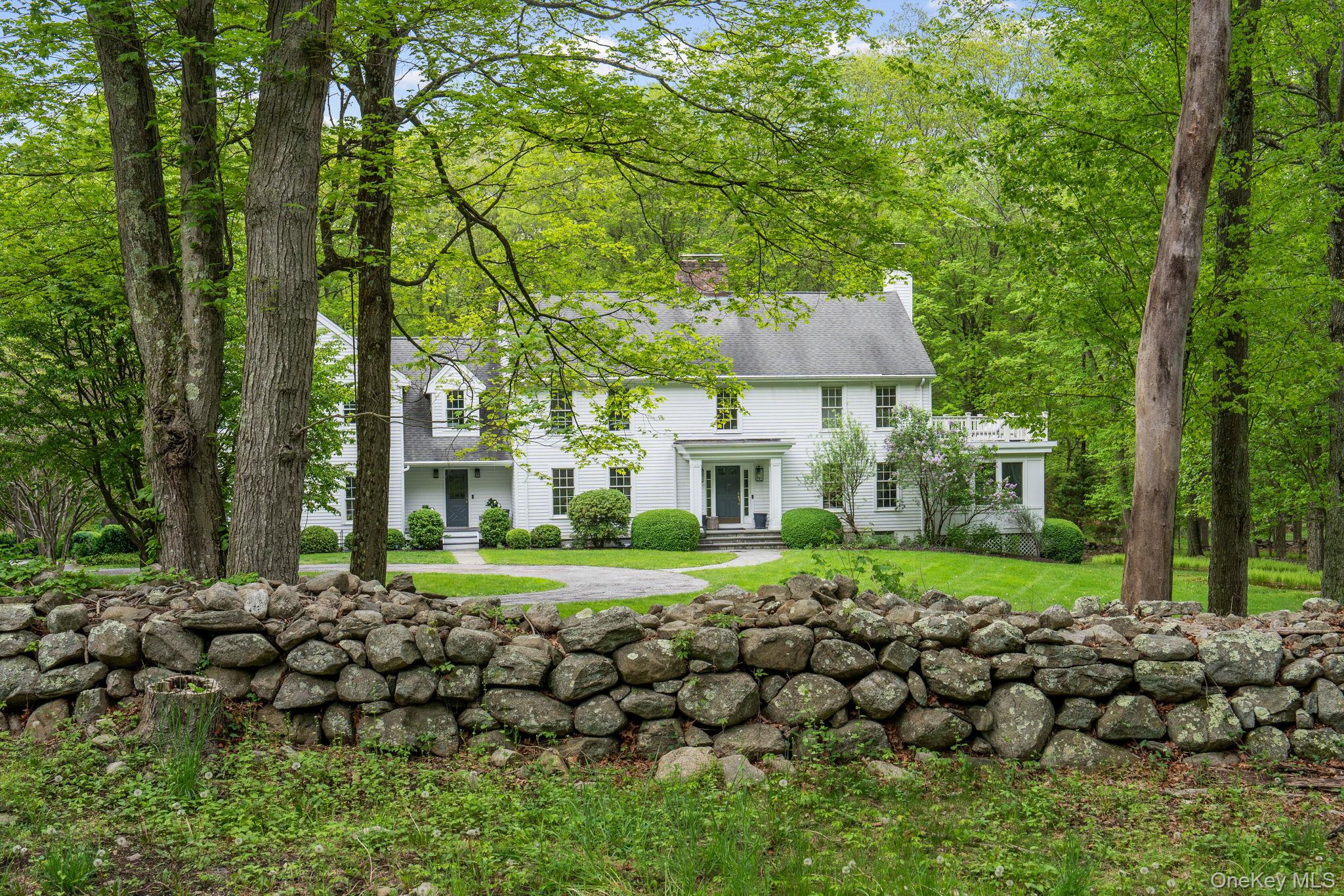 240 Eastwoods Road Pound Ridge, NY 10576 - Photo 1 of 13 a front view of a house with a yard