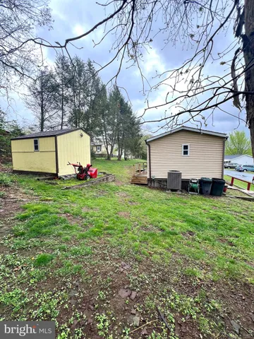 a white house that has a big yard and a big wooden fence
