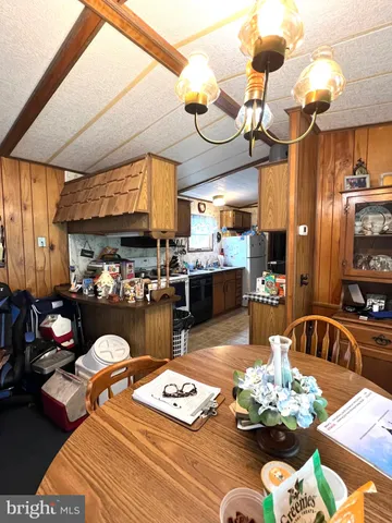 a living room filled with furniture chandelier and kitchen view