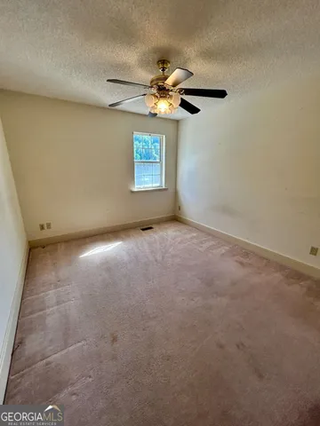 an empty room with a chandelier fan
