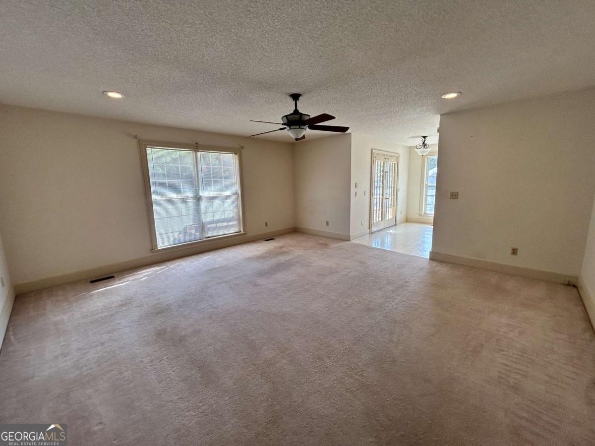 39 Paradise Lake Road Tifton, GA 31794 - Photo 8 of 23 an empty room with windows and ceiling fan
