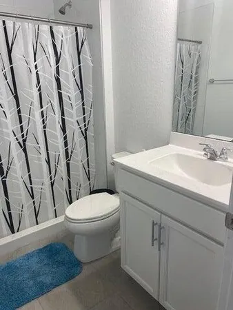 a white toilet sitting next to a bathroom sink