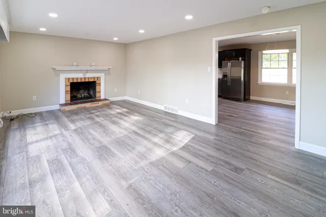 an empty room with wooden floor and fireplace