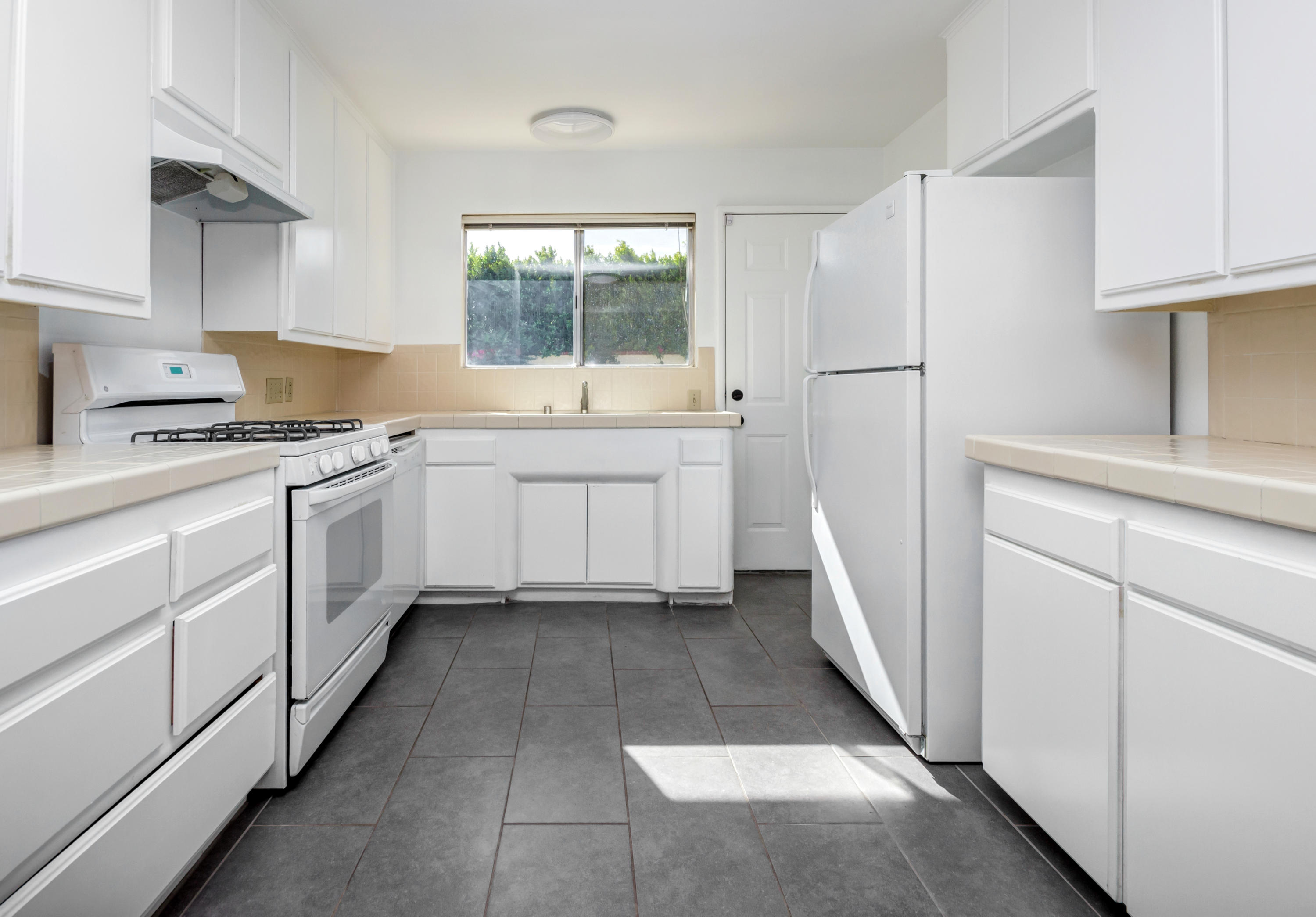 1253 Linda Vista Road Palm Springs, CA 92262 - Photo 13 of 29 a kitchen with white cabinets and white appliances