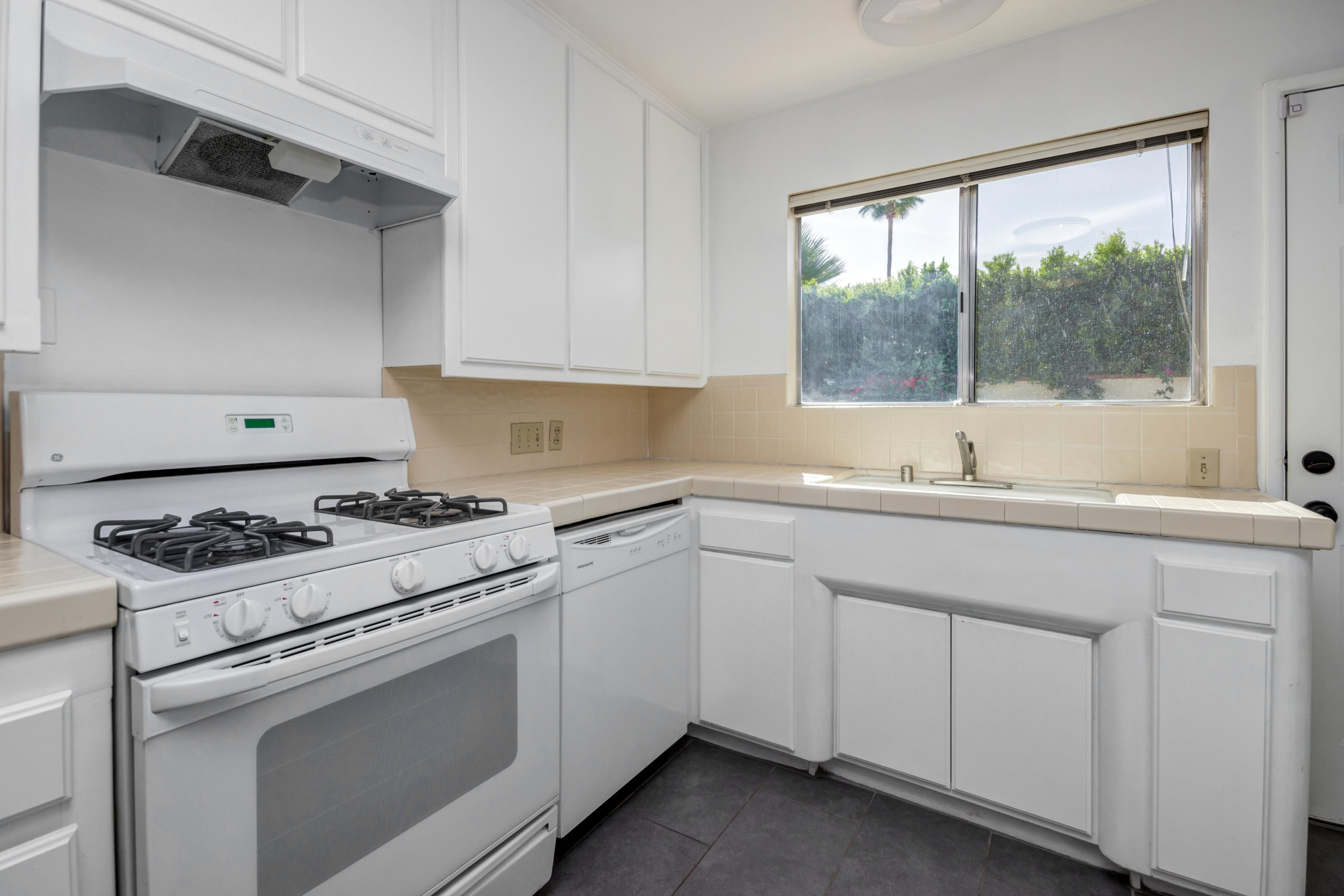 1253 Linda Vista Road Palm Springs, CA 92262 - Photo 14 of 29 a kitchen with granite countertop white cabinets and a sink