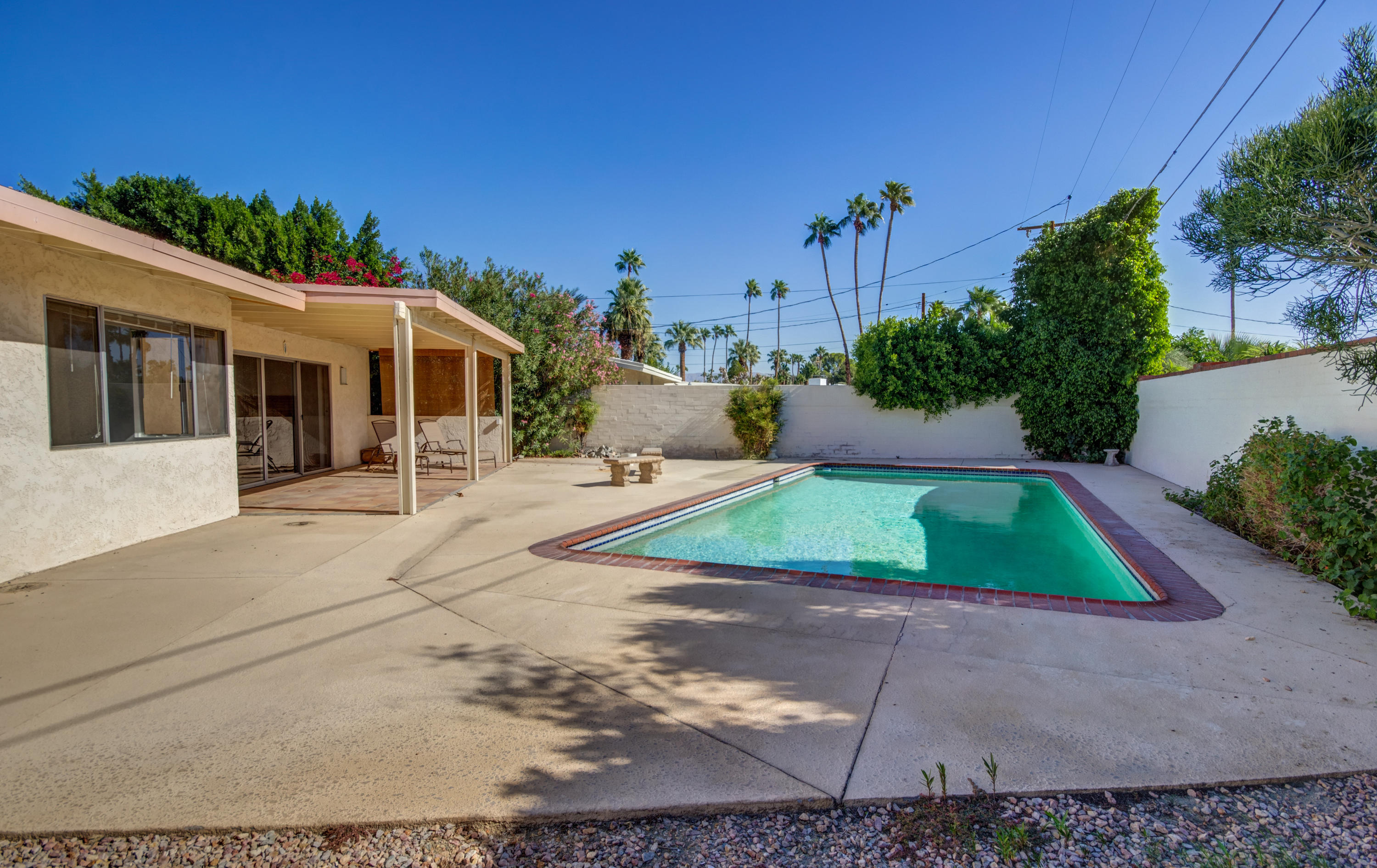 1253 Linda Vista Road Palm Springs, CA 92262 - Photo 28 of 29 a view of a white house with a yard and potted plants