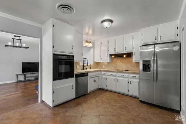 a kitchen with granite countertop stainless steel appliances and white cabinets