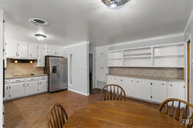 a kitchen with stainless steel appliances granite countertop a stove a sink a refrigerator and cabinets