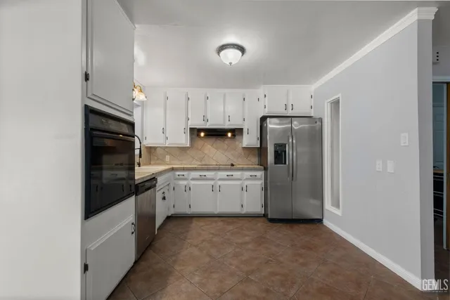 a kitchen with a refrigerator sink and cabinets