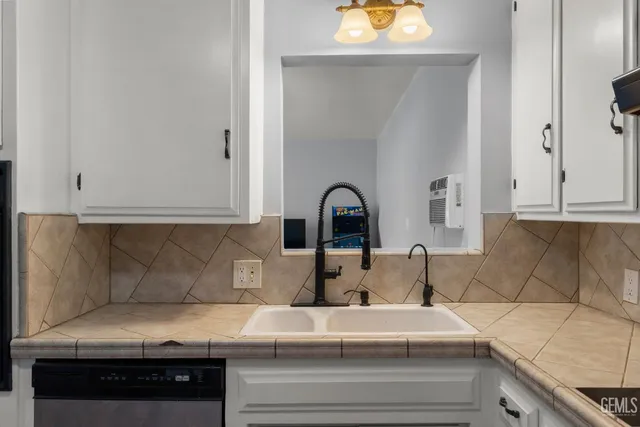 a kitchen with a sink and a stove with wooden floor