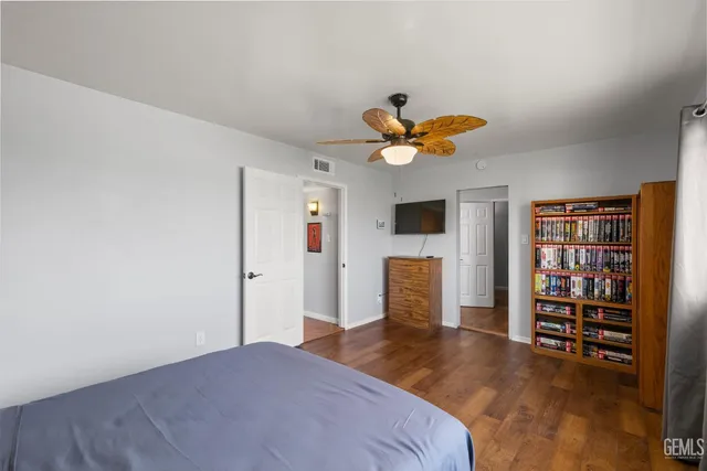a bedroom with a bed and a ceiling fan