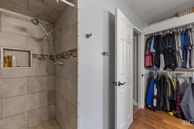 a view of walk in closet with clothes and shoes