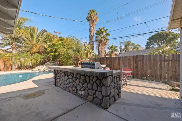 a view of a patio with a table and chairs under an umbrella