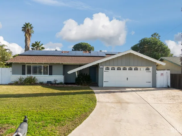 a view of a house with a yard and potted plants