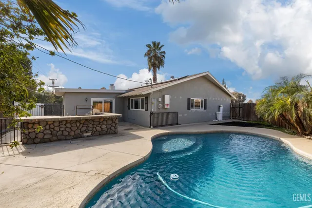 a view of a house with backyard and sitting area