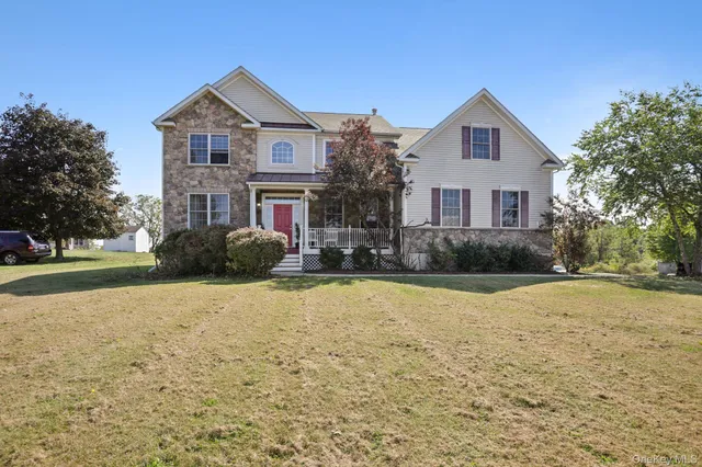 a front view of house with yard and trees around