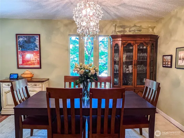 a view of a dining room with furniture a chandelier and wooden floor
