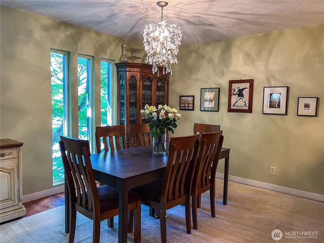a view of a dining room with furniture a chandelier and wooden floor