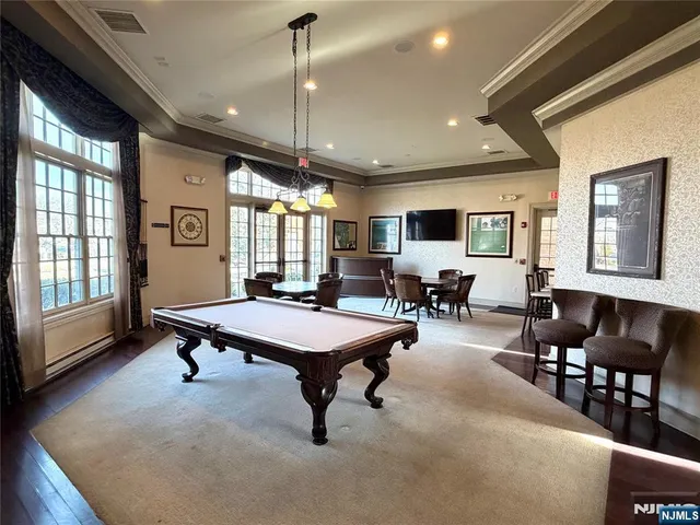 a room with lots of furniture pool table flat screen tv and windows