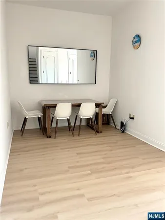 a dining room with wooden floor and white walls