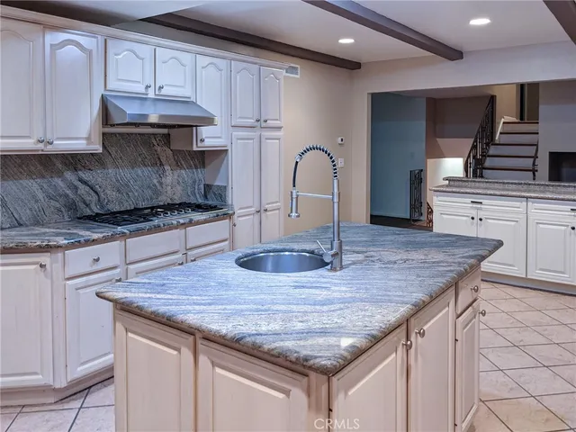 a kitchen with granite countertop a table chairs and cabinets