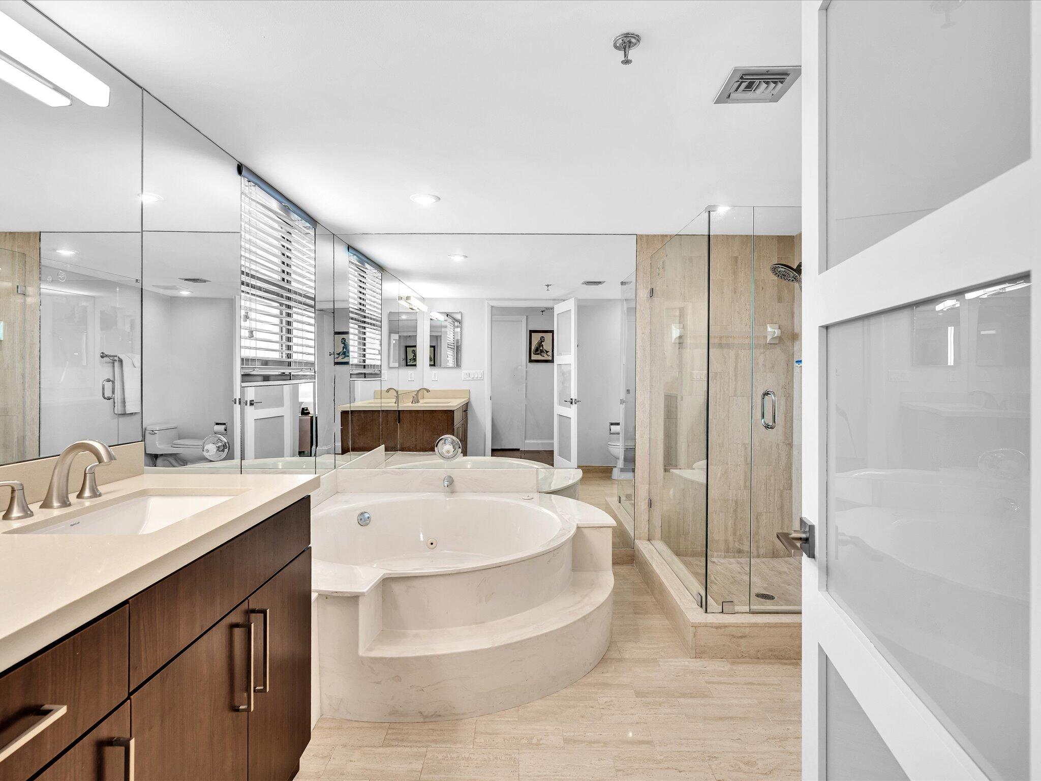 7201 Promenade Drive, Unit 602 Boca Raton, FL 33433 - Photo 12 of 77 a large white bathroom with a double vanity sink a large mirror and shower