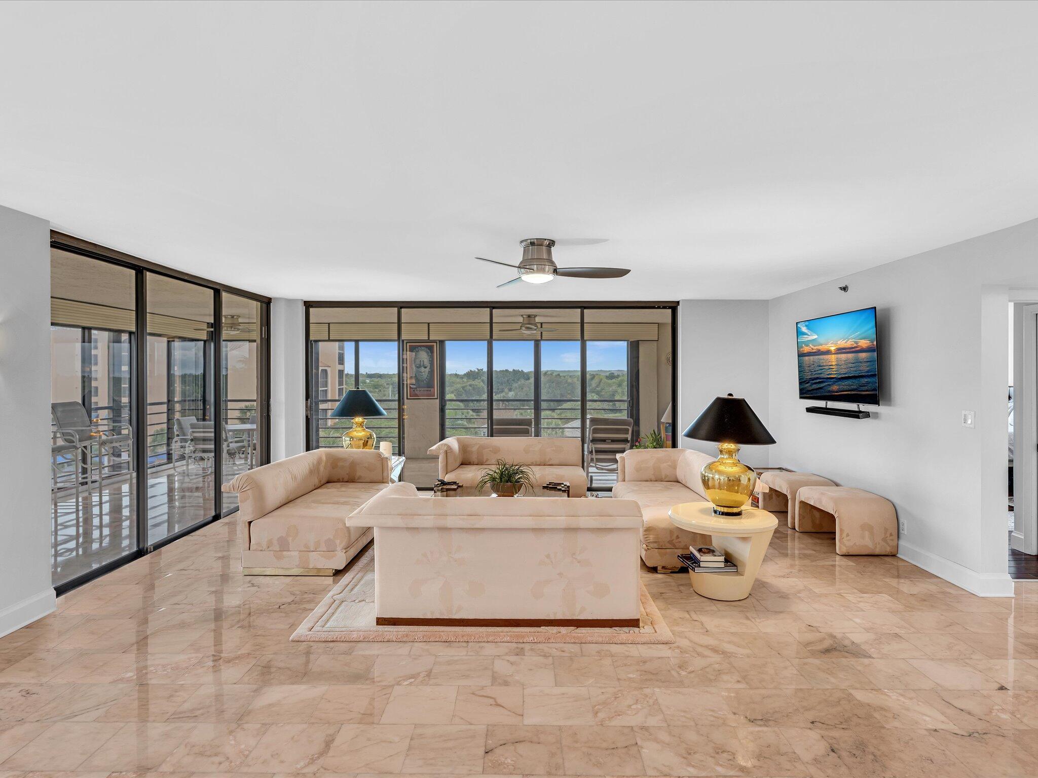 7201 Promenade Drive, Unit 602 Boca Raton, FL 33433 - Photo 27 of 77 a living room with furniture large windows and flat screen tv