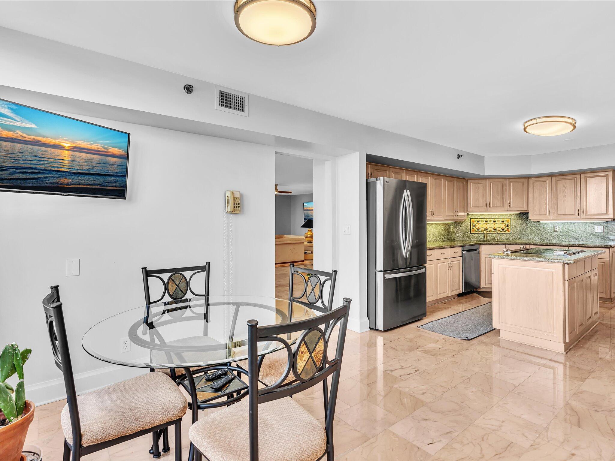 7201 Promenade Drive, Unit 602 Boca Raton, FL 33433 - Photo 38 of 77 a kitchen with stainless steel appliances kitchen island granite countertop a dining table chairs and a refrigerator