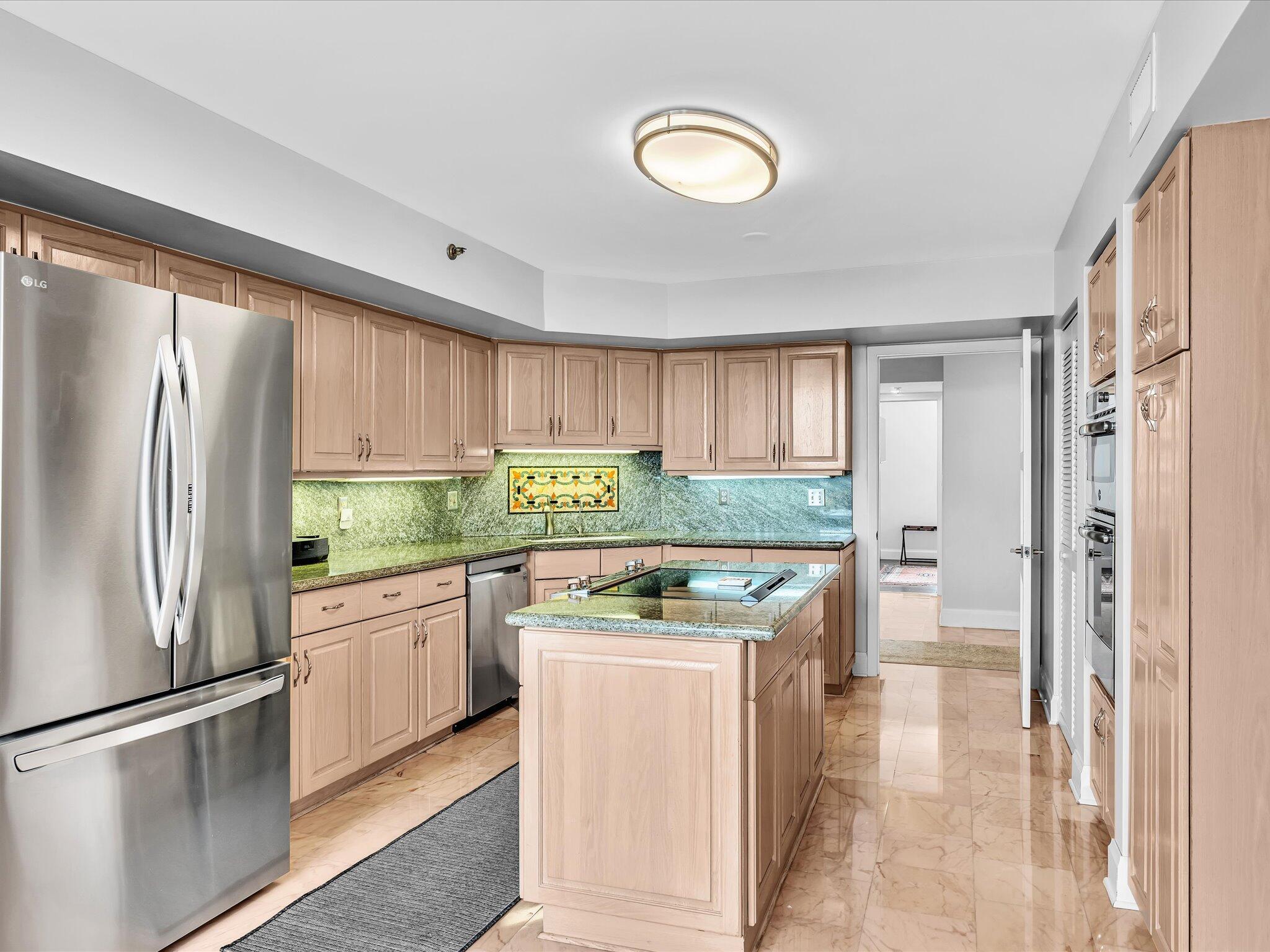 7201 Promenade Drive, Unit 602 Boca Raton, FL 33433 - Photo 41 of 77 a kitchen with stainless steel appliances granite countertop a refrigerator a sink a stove and white cabinets with wooden floor