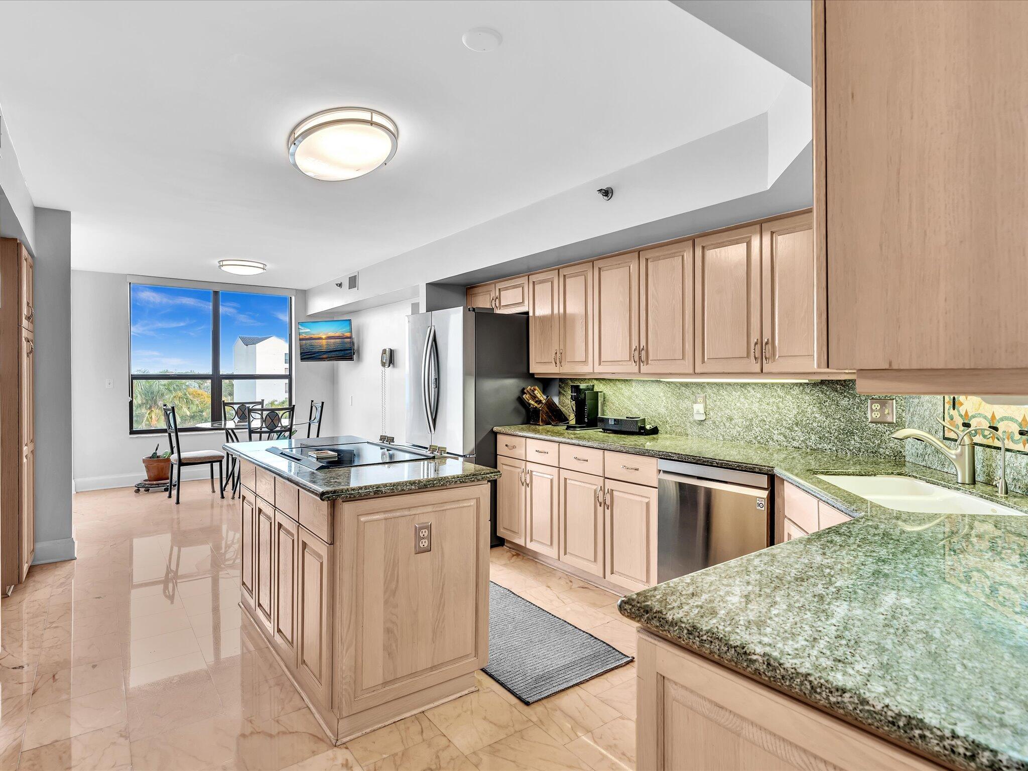 7201 Promenade Drive, Unit 602 Boca Raton, FL 33433 - Photo 42 of 77 a kitchen with stainless steel appliances granite countertop a stove top oven a sink dishwasher and cabinets with wooden floor