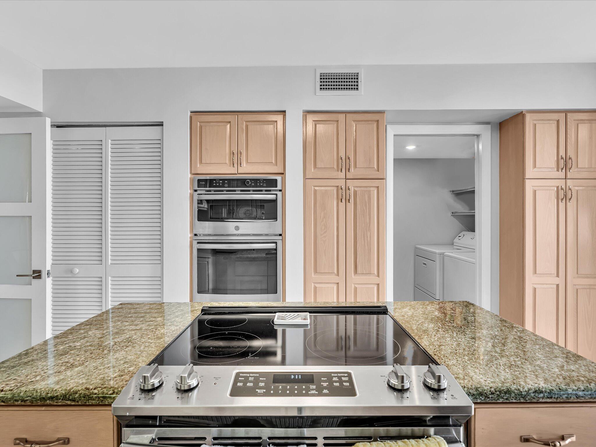 7201 Promenade Drive, Unit 602 Boca Raton, FL 33433 - Photo 10 of 77 a kitchen with granite countertop a stove and cabinets