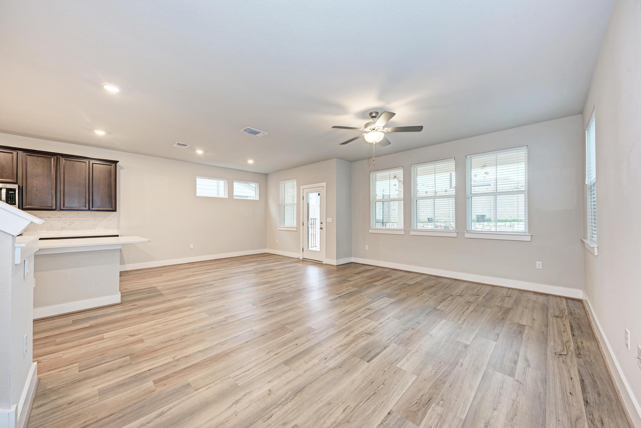 7319 Travertine Spring Drive, Unit 115 Austin, TX 78744 - Photo 13 of 37 a view of an empty room with a window and wooden floor