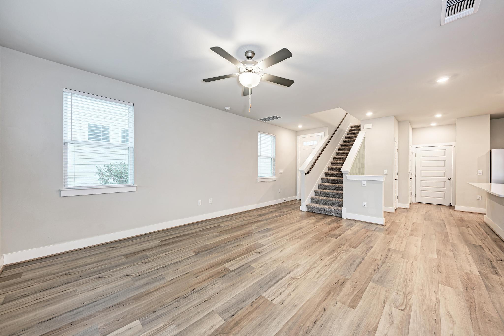 7319 Travertine Spring Drive, Unit 115 Austin, TX 78744 - Photo 14 of 37 a view of an empty room with wooden floor and a ceiling fan