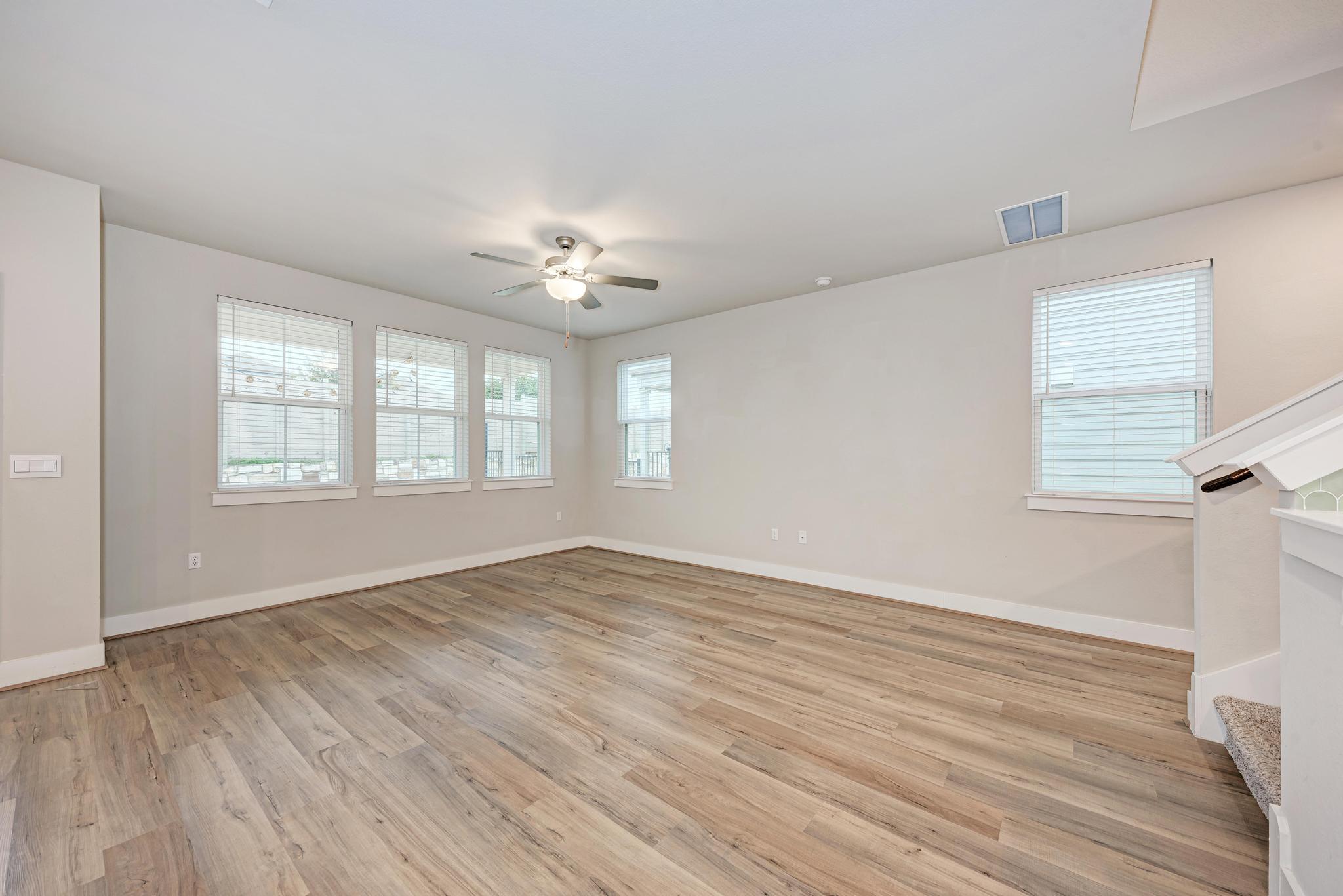 7319 Travertine Spring Drive, Unit 115 Austin, TX 78744 - Photo 15 of 37 a view of an empty room with a window and wooden floor