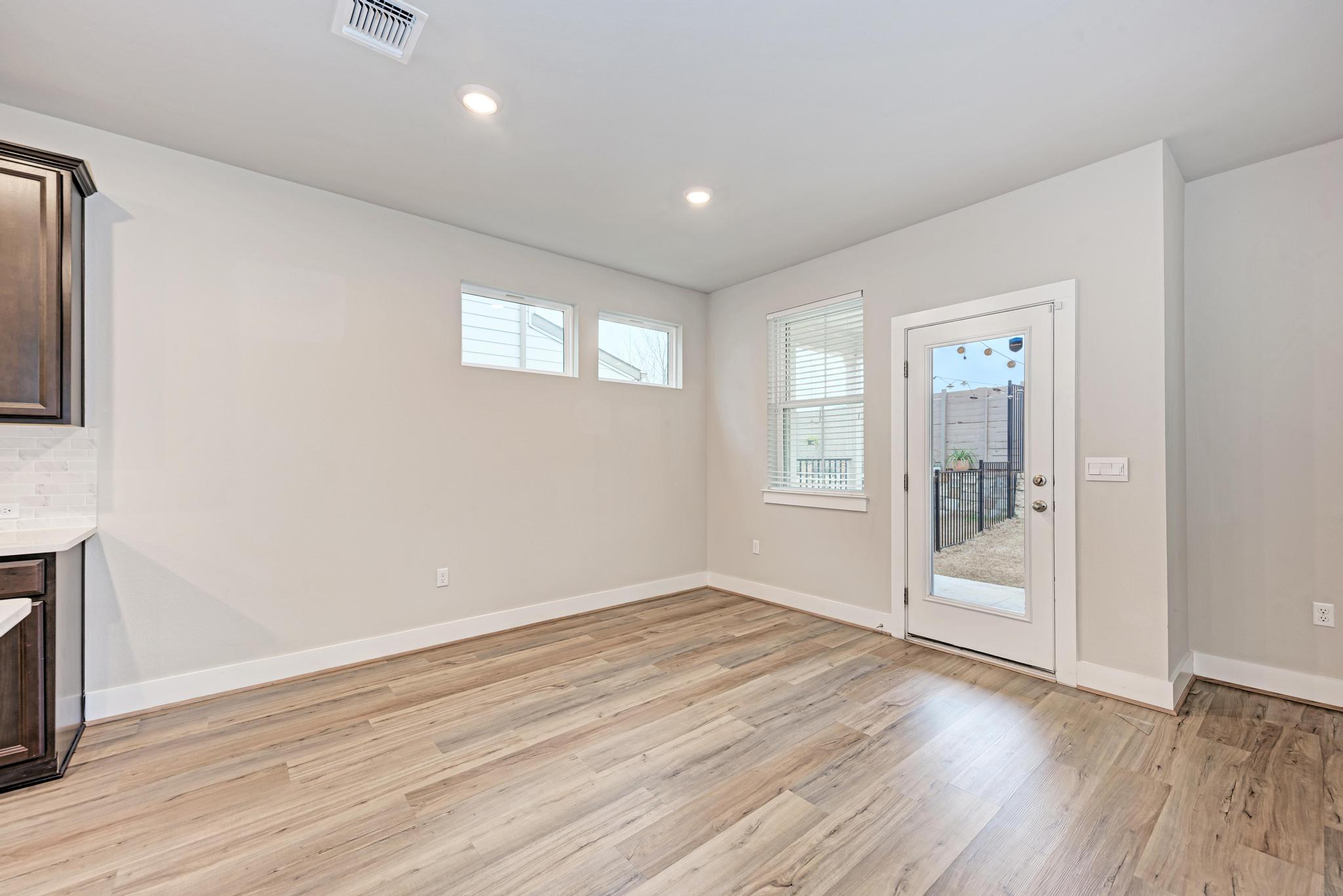 7319 Travertine Spring Drive, Unit 115 Austin, TX 78744 - Photo 17 of 37 an empty room with wooden floor and windows