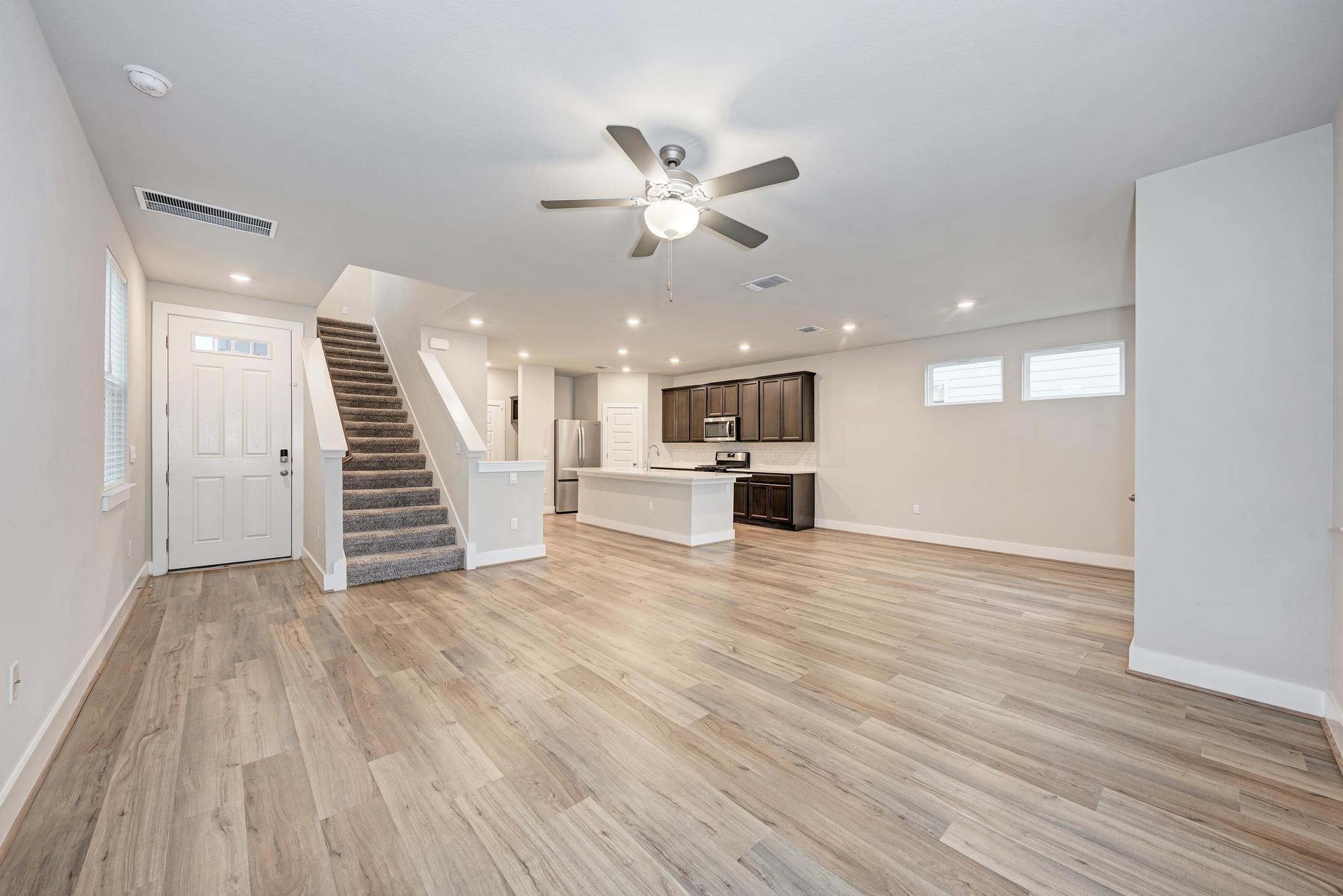 7319 Travertine Spring Drive, Unit 115 Austin, TX 78744 - Photo 2 of 37 a view of an empty room with wooden floor and a ceiling fan