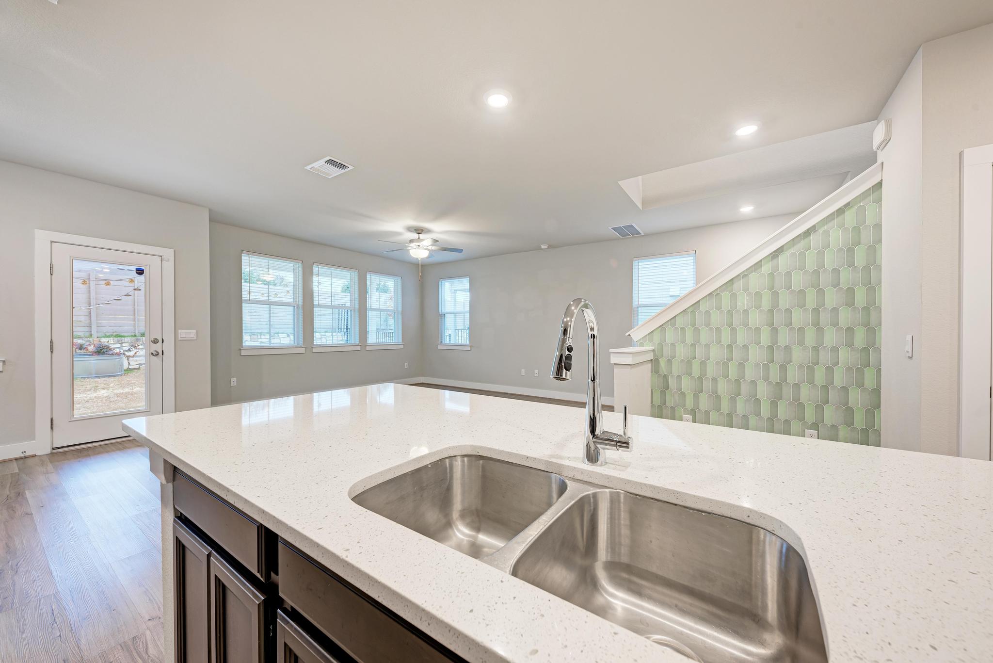 7319 Travertine Spring Drive, Unit 115 Austin, TX 78744 - Photo 20 of 37 a kitchen with a sink and a refrigerator with wooden floor